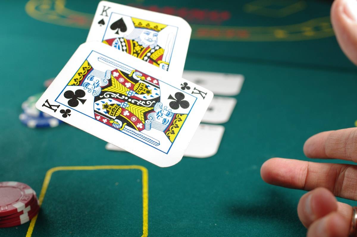 Pemain memegang kartu poker di meja dengan keping bertumpuk